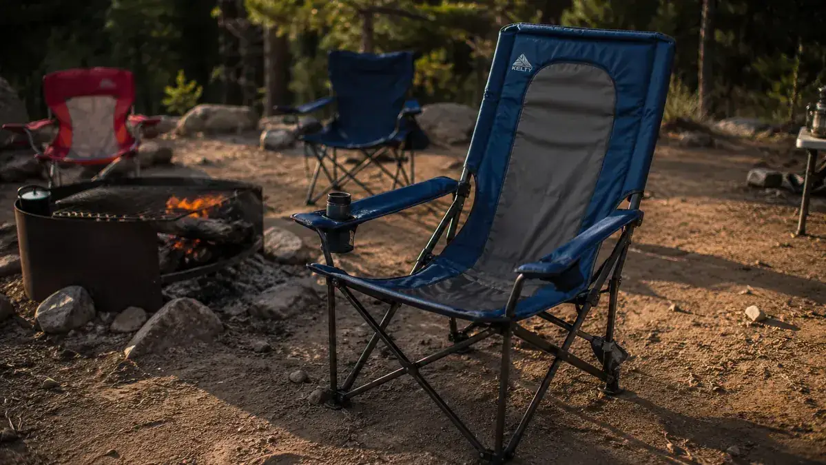 ALPHA CAMP oversized camping chair set up at a campsite in late afternoon light with a fire ring nearby