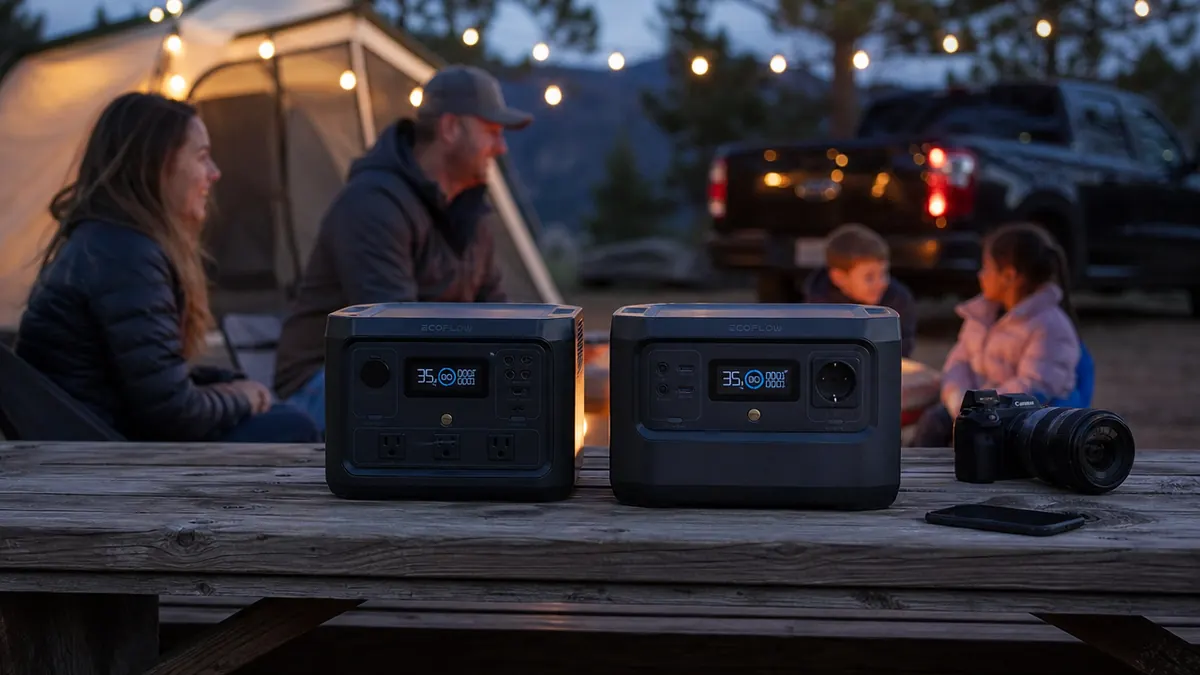 Anker 521 portable power station and a Jackery Explorer 300 style unit sitting side by side on a camp table at dusk