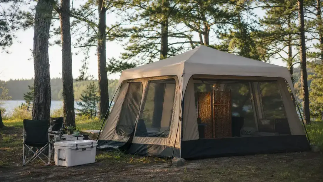 Large family cabin tent set up at a wooded campsite in early morning light